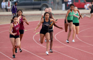Junior Sydney Silas takes the baton from freshman Jade Selmon in the 4x100 relay at the Canyon Lake track meet earlier this season.
