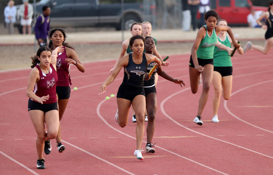 Junior Sydney Silas takes the baton from freshman Jade Selmon in the 4x100 relay at the Canyon Lake track meet earlier this season. 