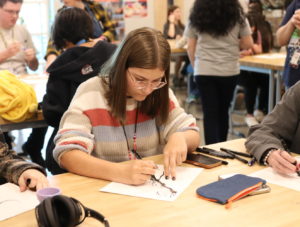 Peyton Perry adds to her ink blot drawing.