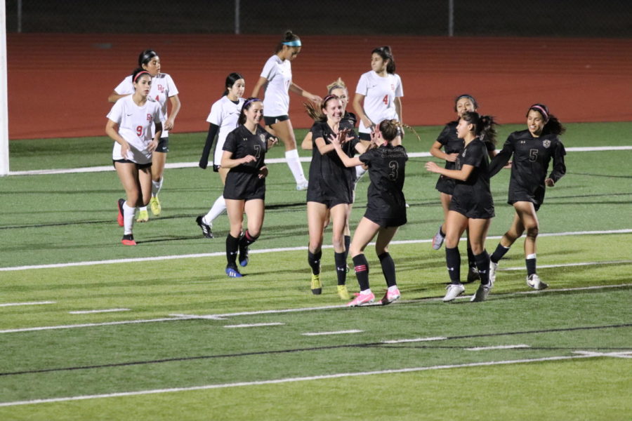 The varsity soccer players celebrate the first of six goals they scored during the game. 