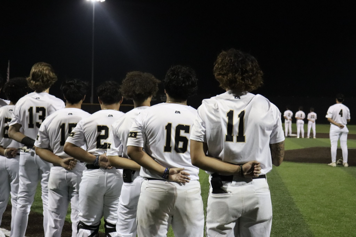 Paying Tribute: 
The Varsity Baseball team honors the national anthem before their game. Previously, they’ve had their share of landslide and close wins. “I think we’re gonna win by a lot,” Ethan McLain said. “I think we’re gonna hit good and field good.”