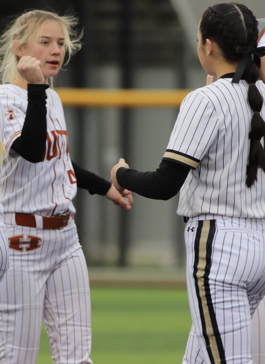 Game Well Played: Sophomore Kaitlyn De La Fuente shakes hands with one of the members of the Hutto High School softball team after their win. De La Fuente started softball when she was four years old and loves how fast-paced the sport is. “We won our first four games, and then Saturday we lost our last game,” De La Fuente said. “But we started off strong, and although we didn’t win all our games, it was still a good weekend.”
