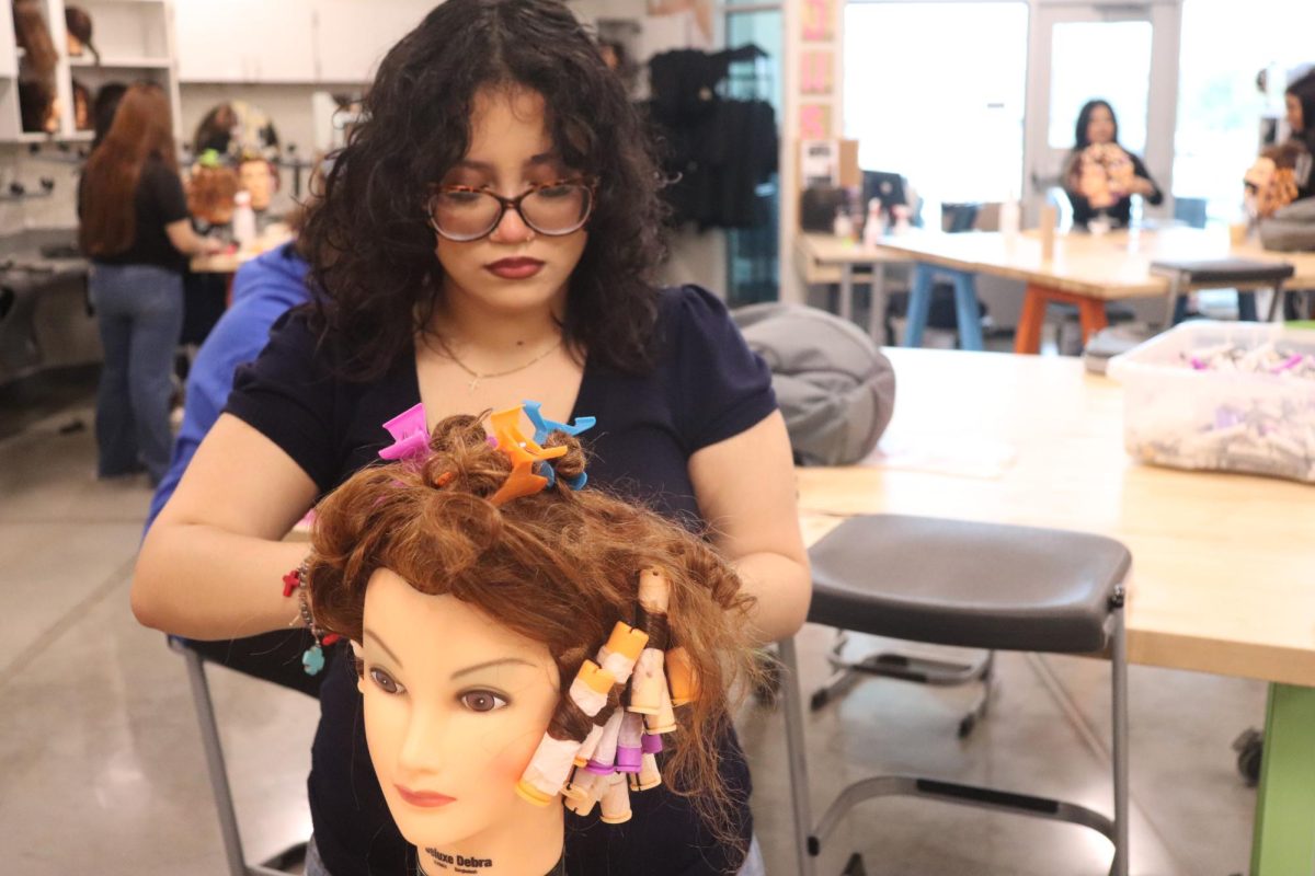 Trials of being taught the technique for hair: Eileen Zavala working hard on her mannequins hair with many types of hair accessories. She uses hair clips in order to hold the hair out of the way of the back of the mannequins head so she can work on the hair on the back side of the head. “I’ve always love doing my hair and makeup at home,” Eileen Zavala said. “I want to be a nail technician for a couple of years.”
