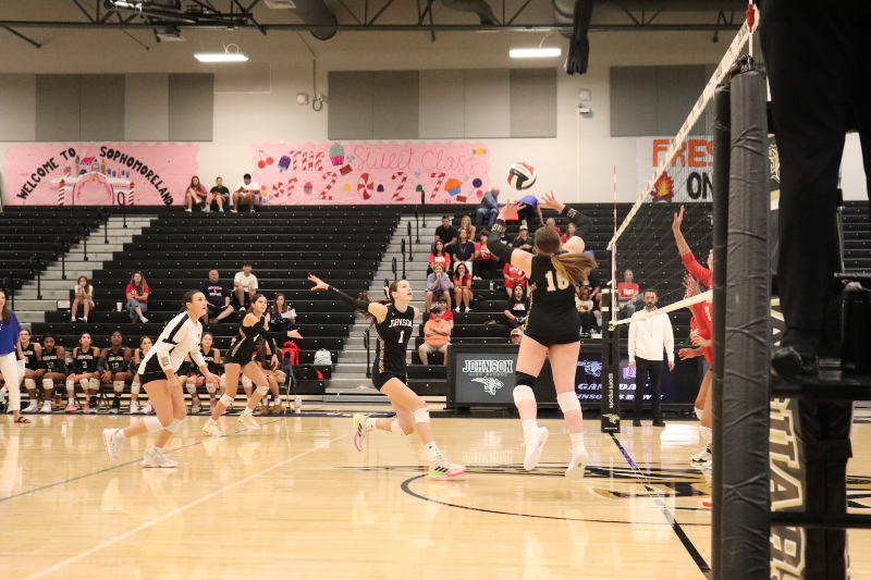 JV volleyball player Chloe Switzer jumping to set the ball.