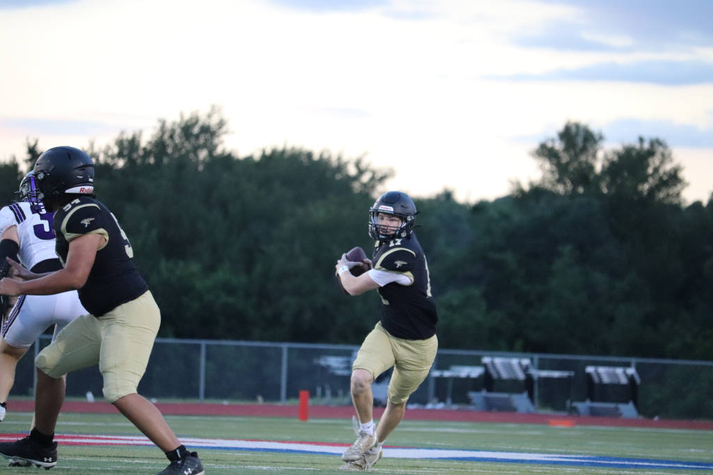 JV Black team quarterback Chase Gregory running with the ball down the field.