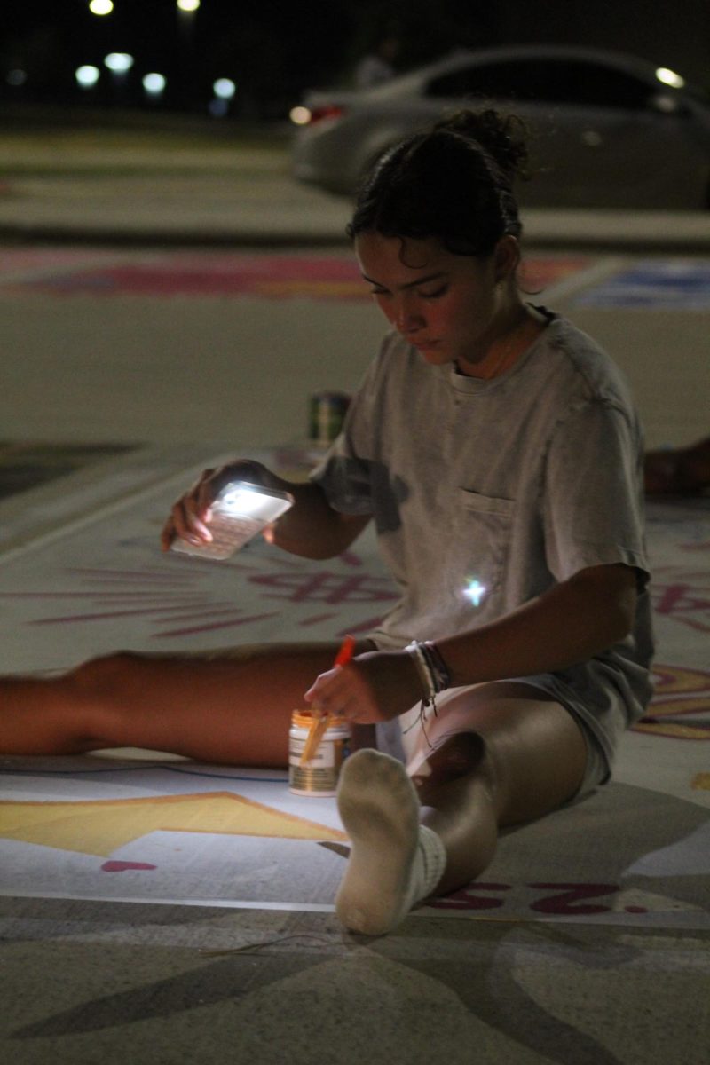  Sofia Galvan painting Senior Isabella Galvan’s reserved parking spot at night. 