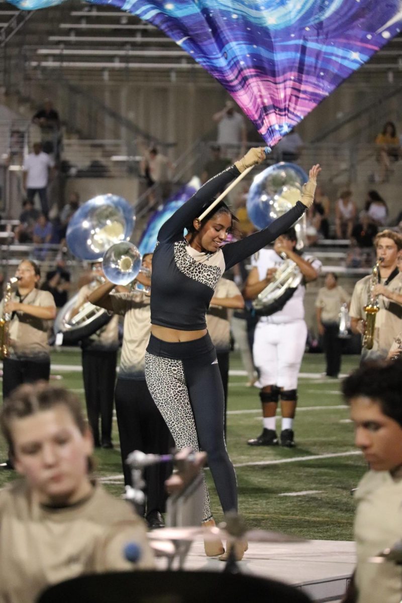 Senior Jescelyn Johnston performing her solo dance with the color guard during their halftime performance.