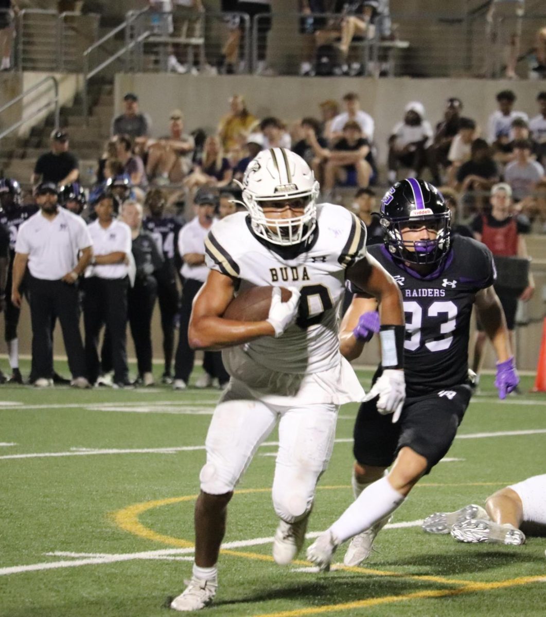 Running back Kael Hatnot running down the field carrying the ball. 