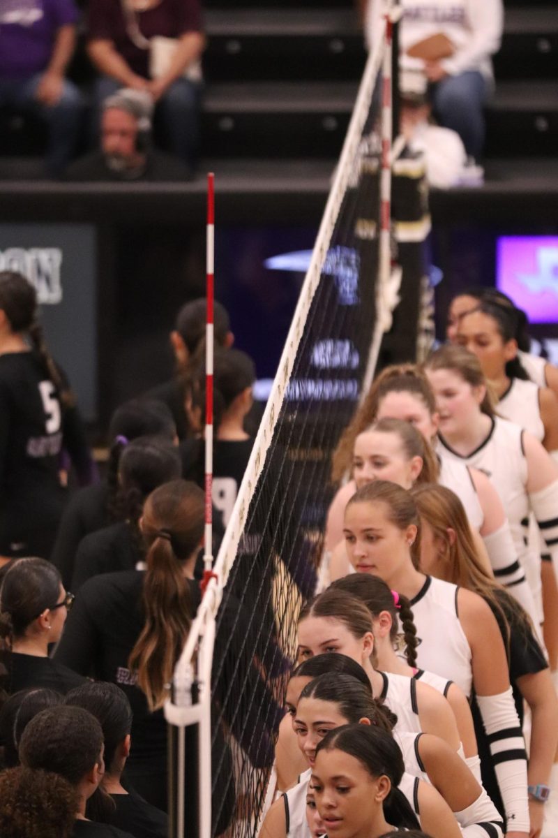 Varsity volleyball girl's pat hands with San Marcos Rattlers before their district match. 