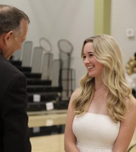 Junior Ava Schlotterbeck waiting with Academic dean Tim Jacobson for her A Honor Roll award at the academic award ceremony on Oct. 30.