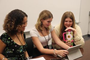 Senior Ariana Dees, junior Elsie McCabe and junior Charlotte Newby creating the BIA presentation for PSAT day. 