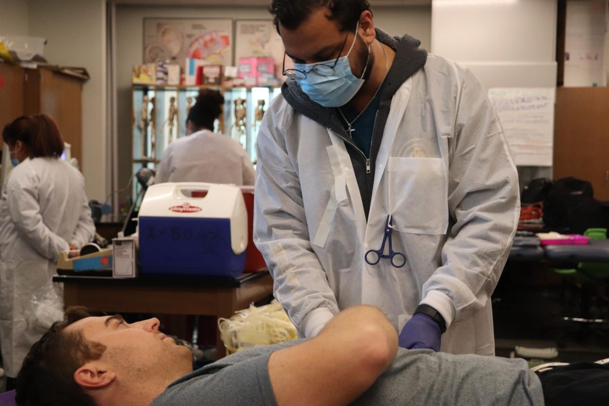 A We Are Blood staff member assisting a donor with blood transfusion.