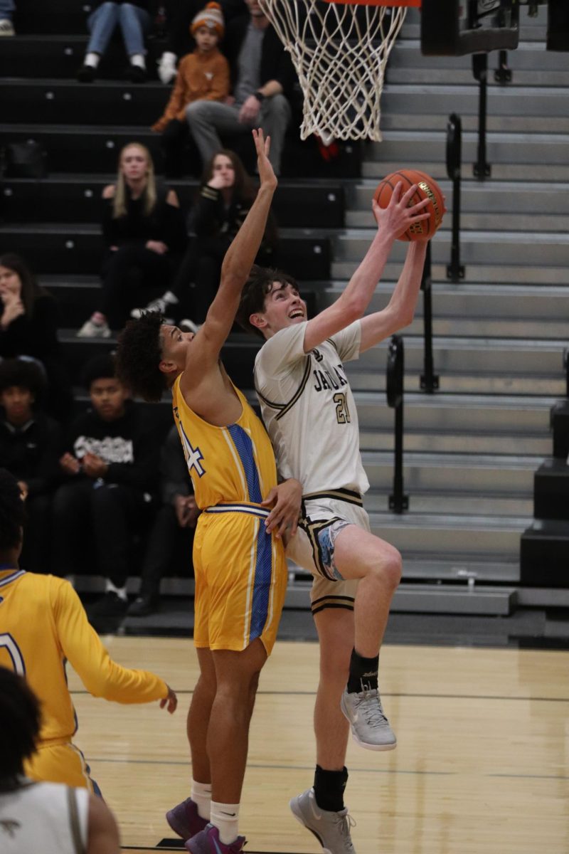 Freshmen James Armend jumping to lay up the basketball in the net.