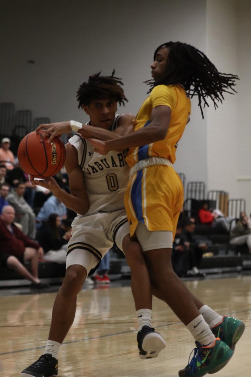 Junior Jayvonne Flores trying to block his opponent from gaining control of the basketball. 