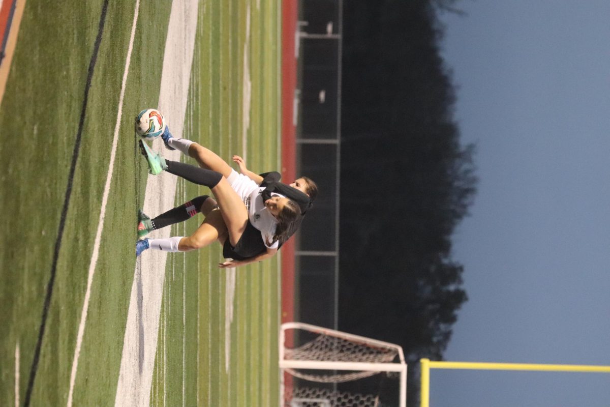 Varsity Captain Jadyn Jaeger attempting to kick the ball away from her Steele opponent. 