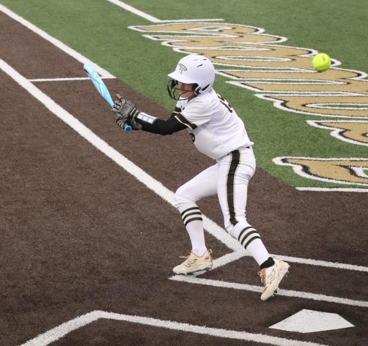 Kinlee McGuire running to first base after hitting the ball. 